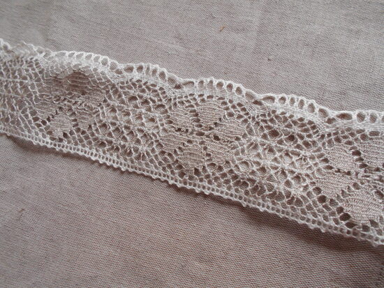 Lina mežģīne  ar pelēkām rozītēm un baltām maliņām, 70 mm plata