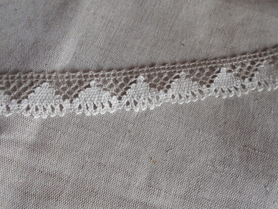 Lina mežģīne  dabiskā lina krāsā ar ieaustiem baltiem trīsstūrīšiem, 25 mm plata